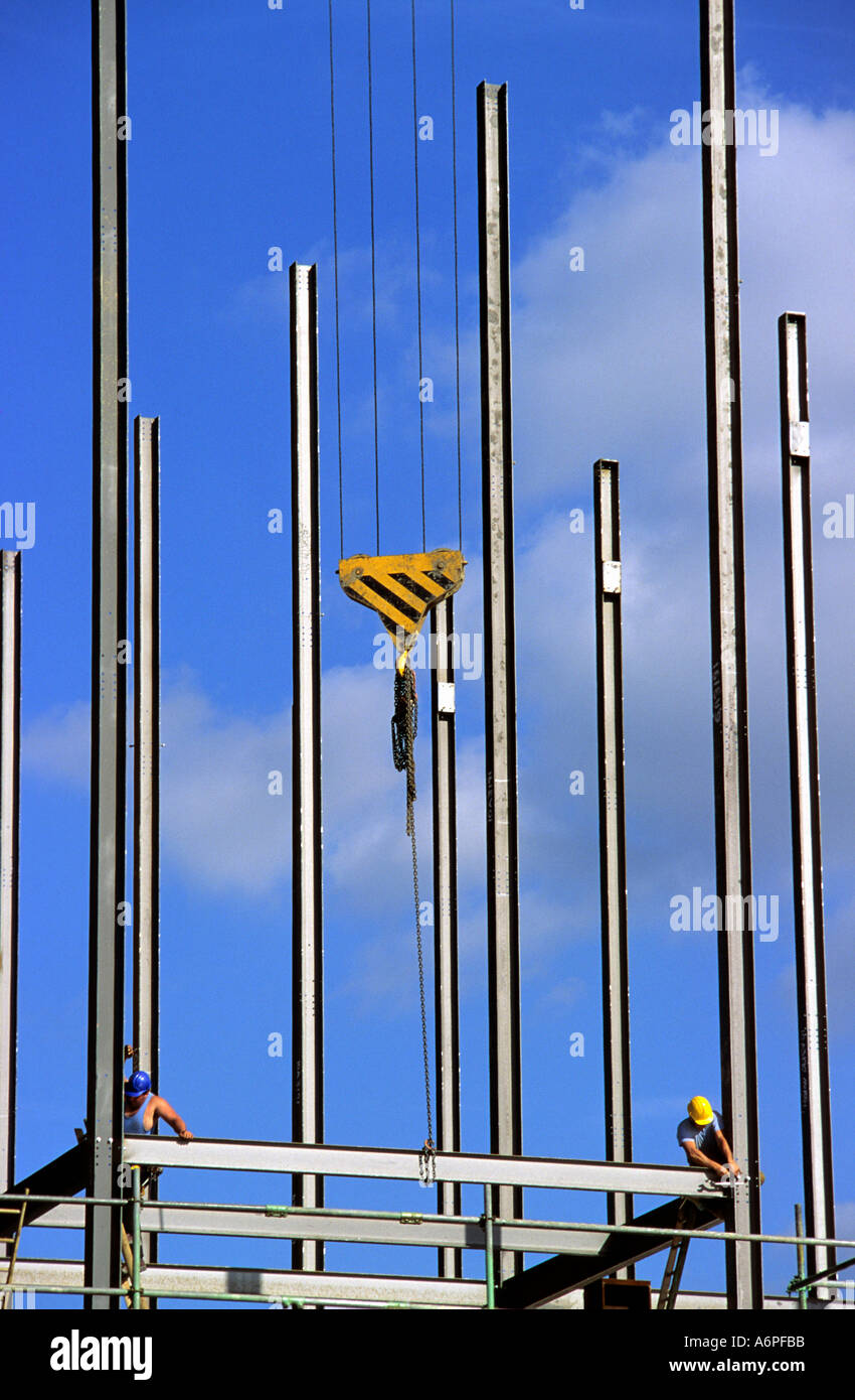 Les travailleurs de la construction à poutres en acier pour fixation suspendue le cadre de levage de la grue sur chantier en Leeds UK Banque D'Images