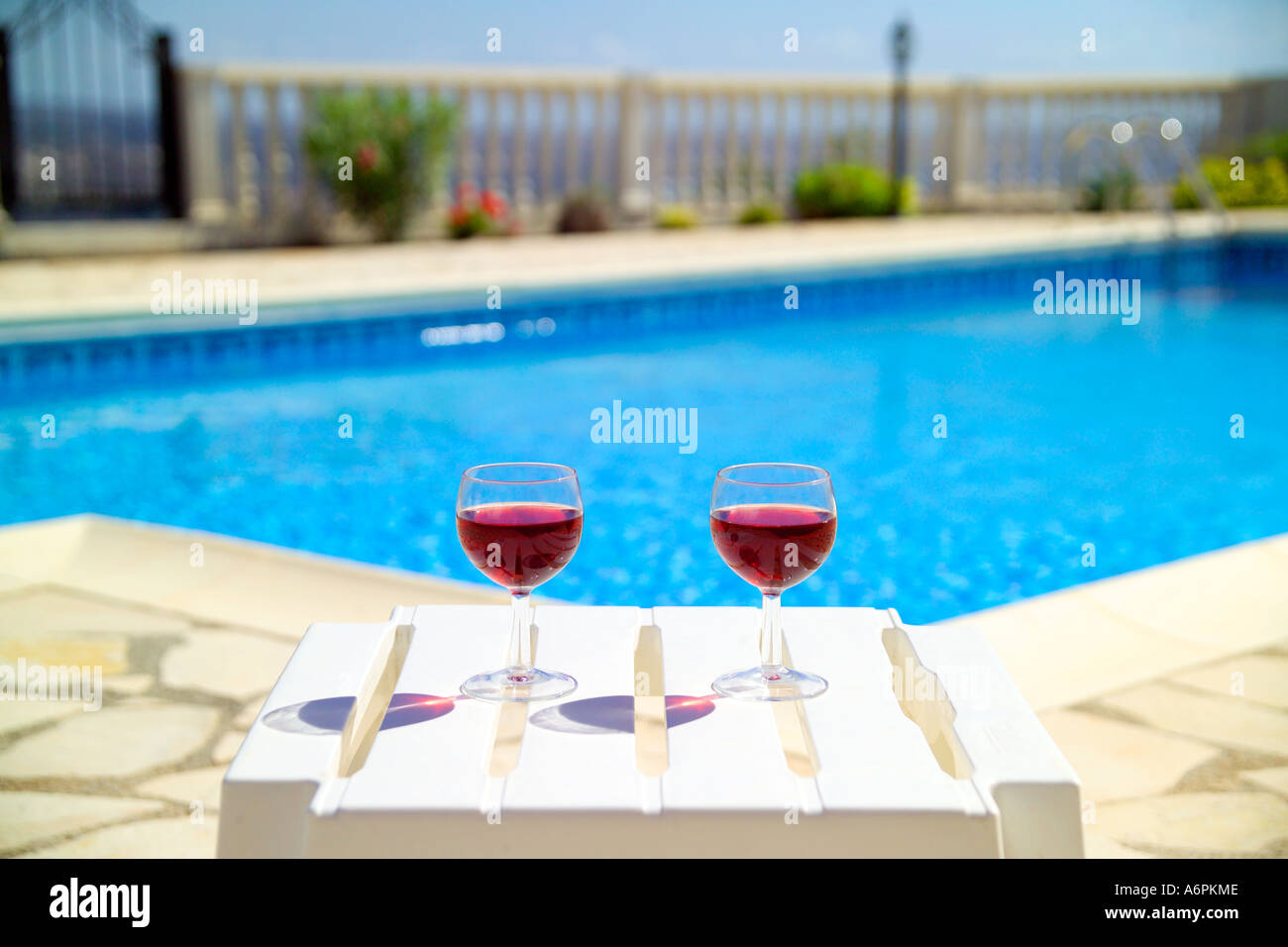 Deux verres à vin rouge à côté DE PISCINE À CHYPRE AVEC VUE EN DISTANCE Banque D'Images