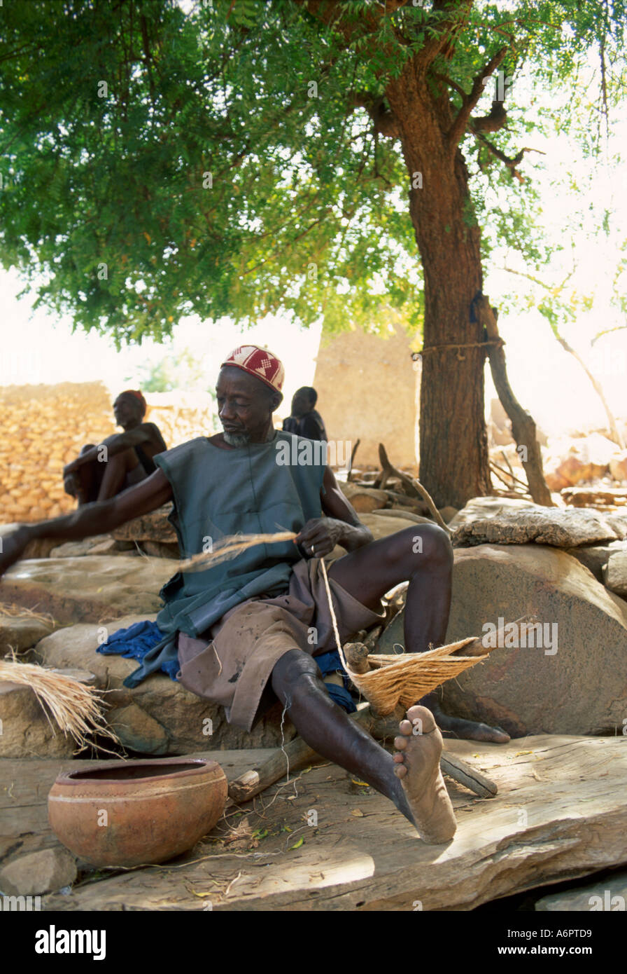Portrati d'un village aîné faisant la corde à partir de fibres d'arbre de baobab. Mali Banque D'Images