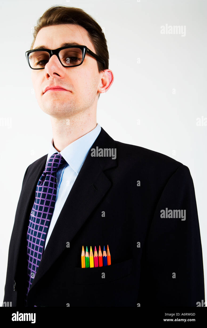 L'homme d'affaires en costume sombre portant des lunettes cerclées lourde et épaisse de couleur avec des crayons de couleurs dans sa poche de poitrine Banque D'Images