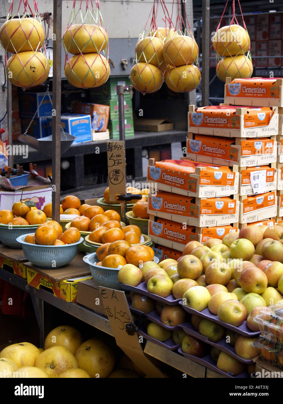 Les oranges, les pommes, les pomelos et à la vente à un stand de fruits en plein air dans le quartier chinois de Manhattan. Banque D'Images