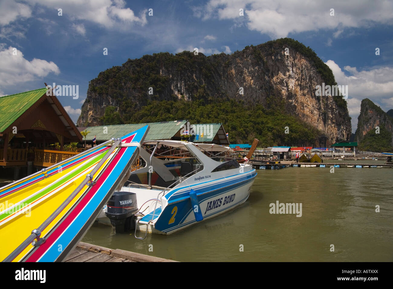 Proue colorée de bateau local et hors-bord modernes nommé James Bond au village de l'eau musulmane Koh Panyi Baie de Phang Nga en Thaïlande Banque D'Images