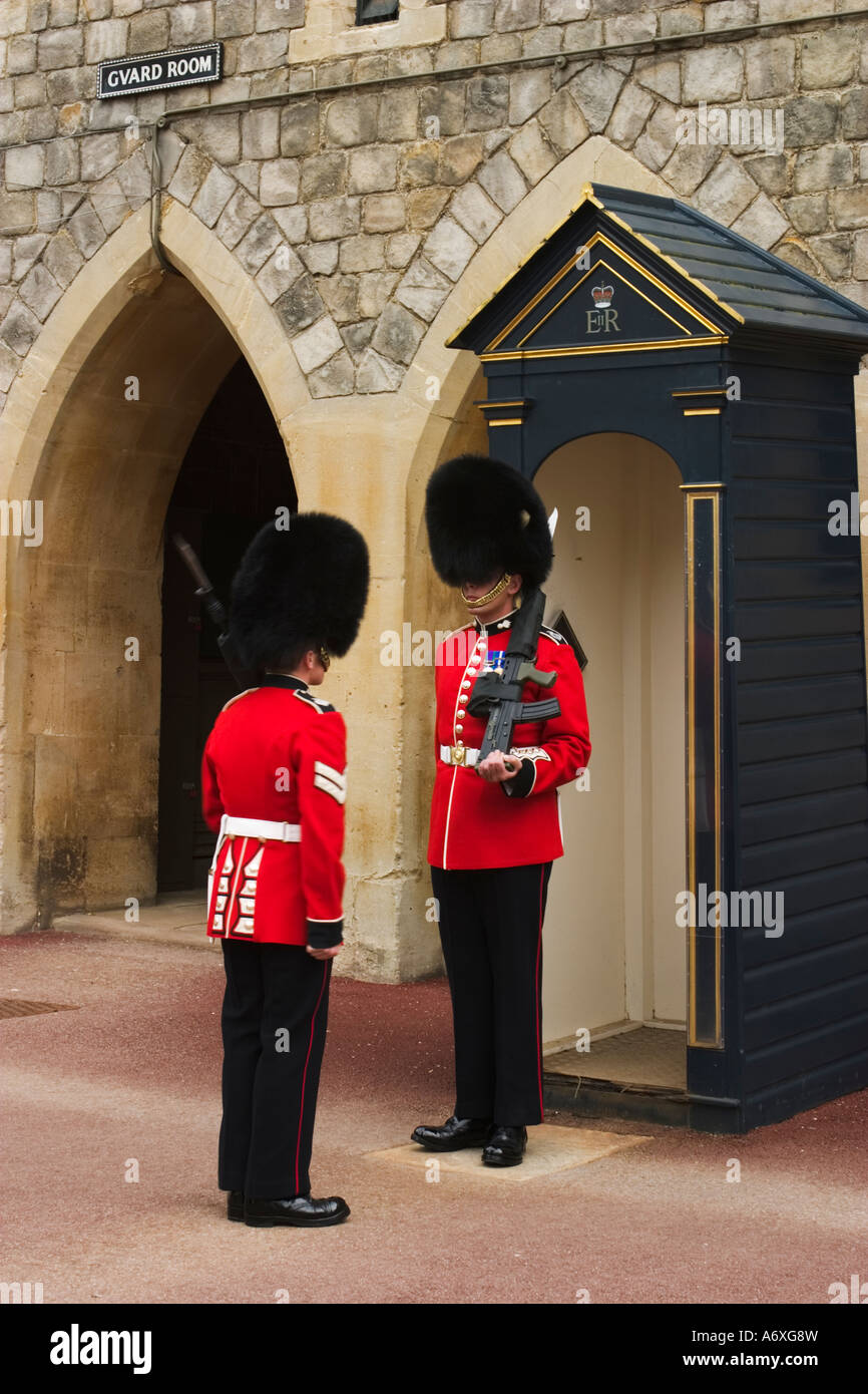 Angleterre Windsor deux hommes en uniforme rouge stand par guérite salle des Gardes voûtée sur signe porte le château de Windsor Banque D'Images