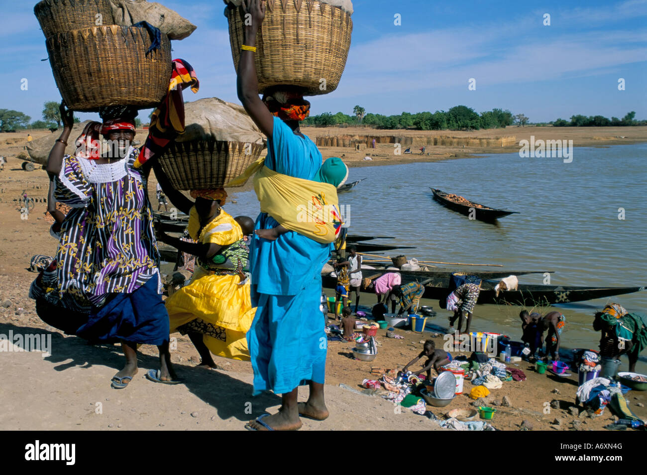 Les femmes avec des paniers de linge sur la tête à côté de la rivière Djenné Mali Afrique Banque D'Images