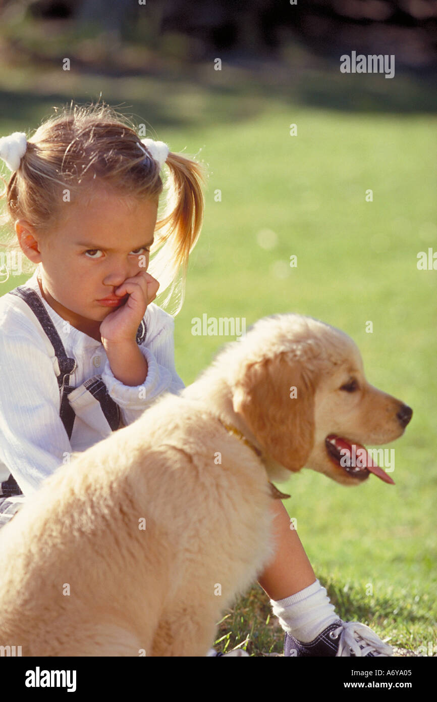 Portrait d'une triste fille assise dans le parc avec un chien Banque D'Images