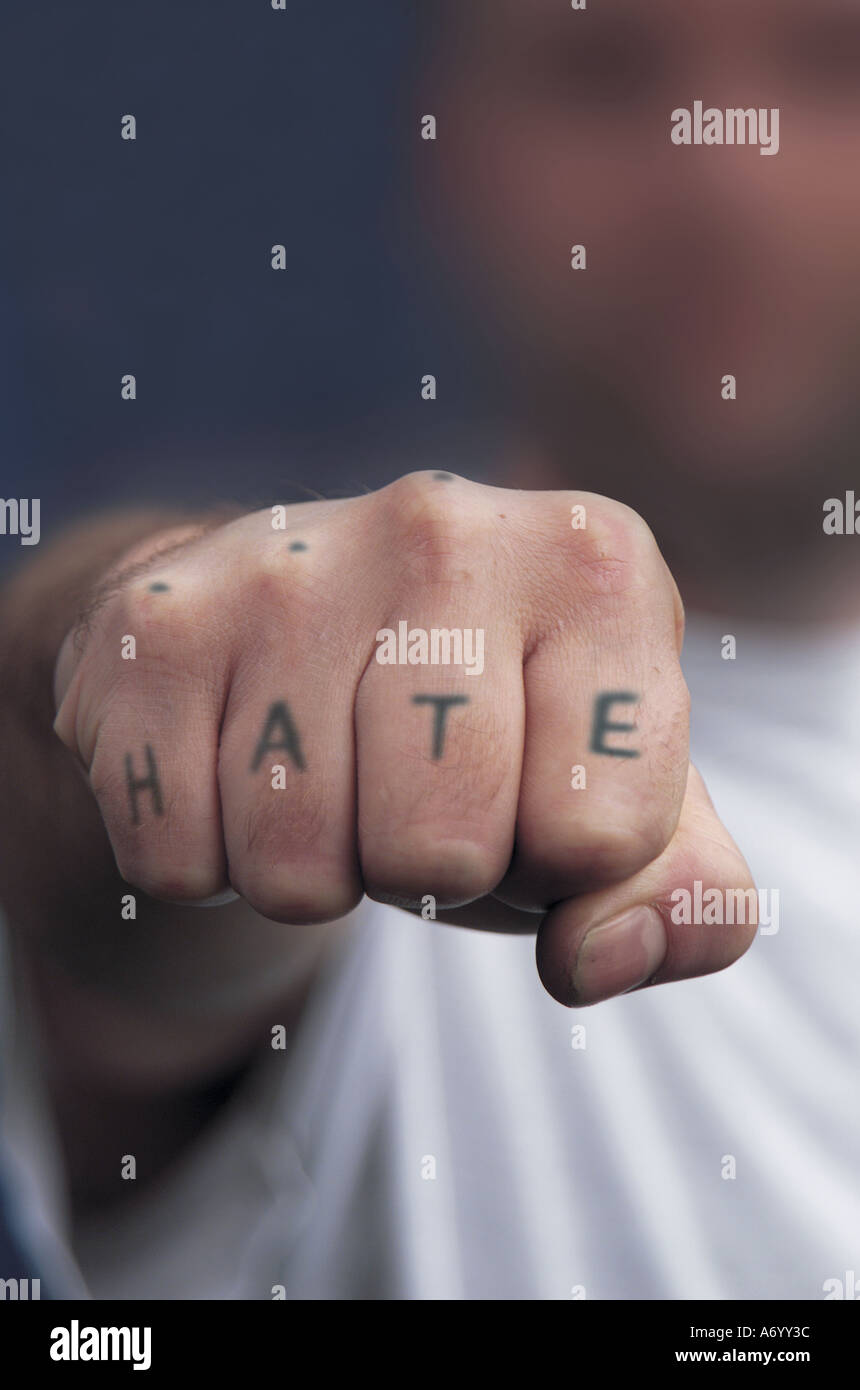 Poing serré avec tatouage de haine sur les jointures Banque D'Images