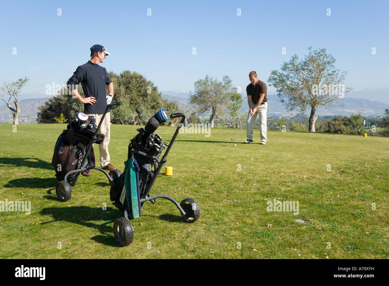 Alhaurin de la Torre, la province de Malaga, Costa del Sol à l'intérieur des terres, au sud de l'Espagne. Lauro Golf. Deux hommes à jouer. Banque D'Images