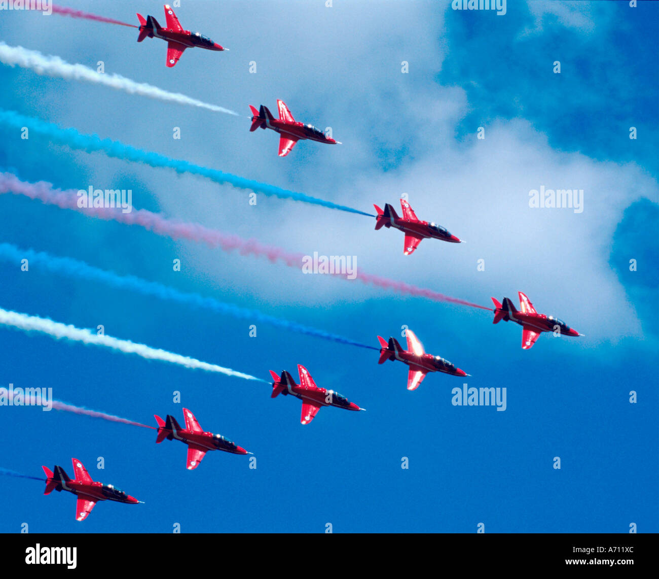 Les flèches rouges trailing red, white and blue smoke photographié contre un ciel bleu Banque D'Images