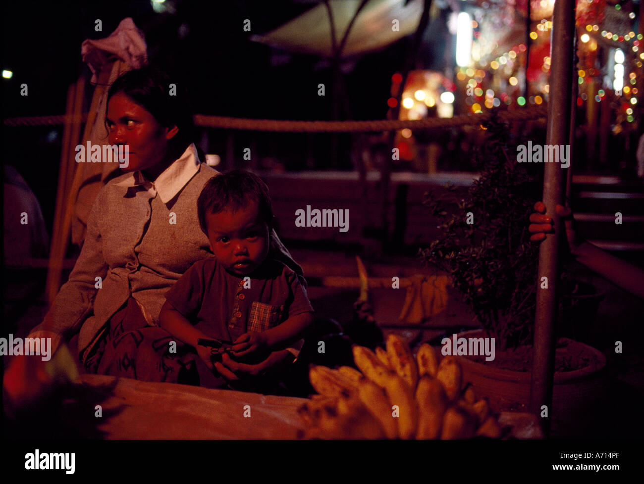 Cambodge Phnom Penh la mère et le fils s'asseoir à la fruit fournisseurs ainsi Sisowath Quay par Tonl Sap sur week-end soir Banque D'Images