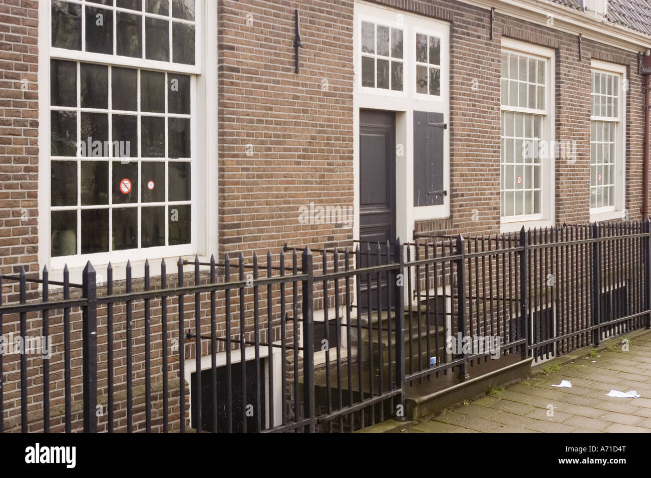 Extérieur de la synagogue portugaise dans l'ancien quartier juif Jodenbuurt, Amsterdam, Hollande, avec des murs de briques et une clôture en métal noir. Banque D'Images