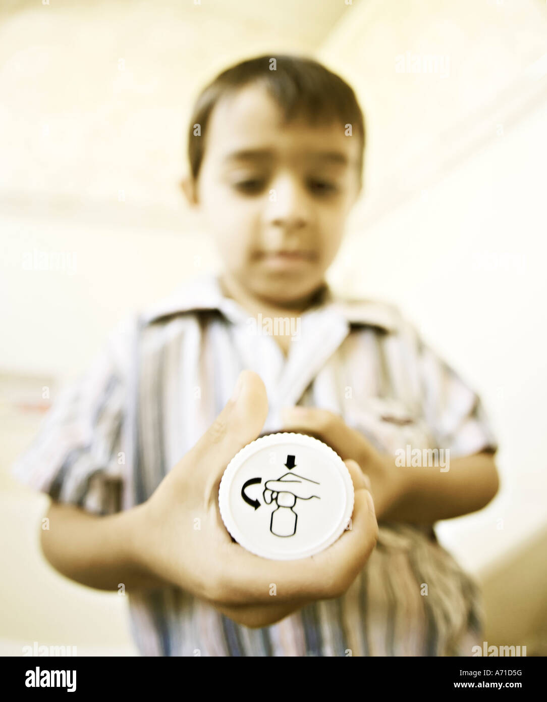 L'enfant essaie de les ouvrir à leur épreuve haut de medicine bottle Banque D'Images