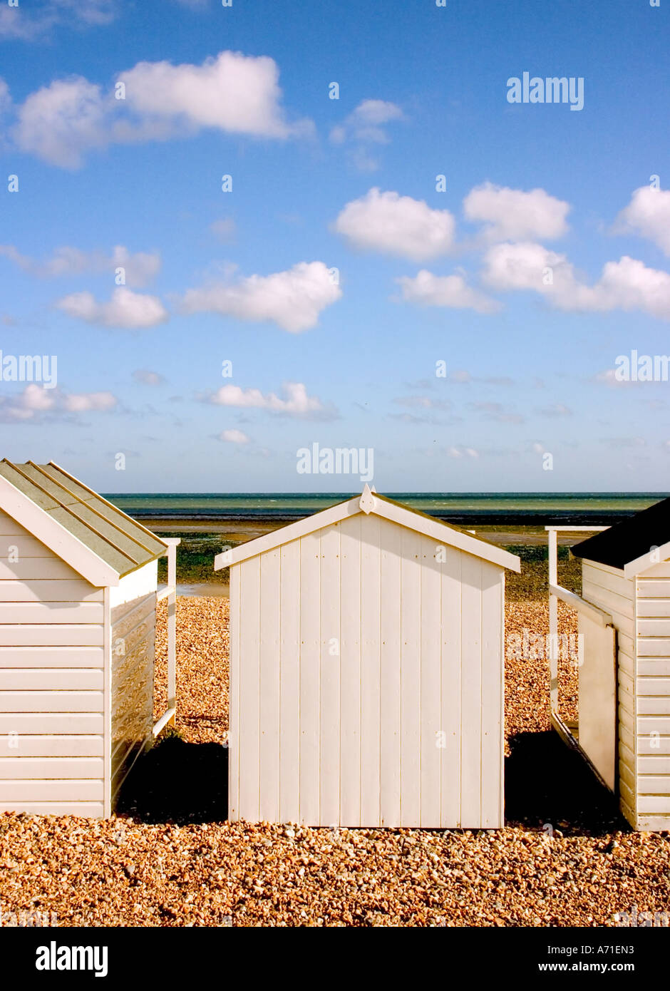Cabines de plage blanc sur une plage de galets dans le Sussex, Angleterre. Banque D'Images