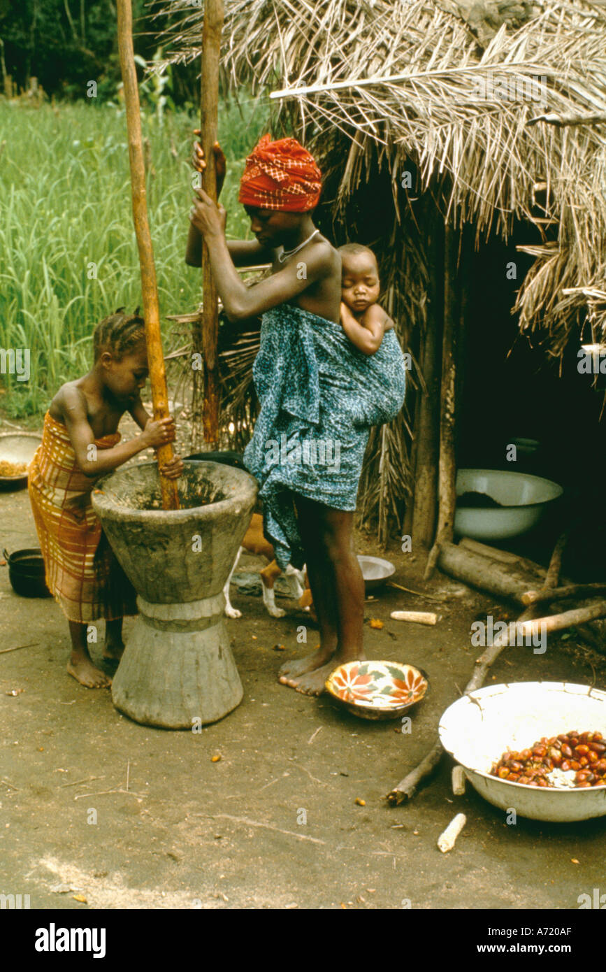 Jeune Femme Africaine Avec Bebe Attache Sur Son Dos Et Les Jeunes Filles Le Fruit Du Palmier Africain Pounding Tribu Kpelle Liberia Photo Stock Alamy