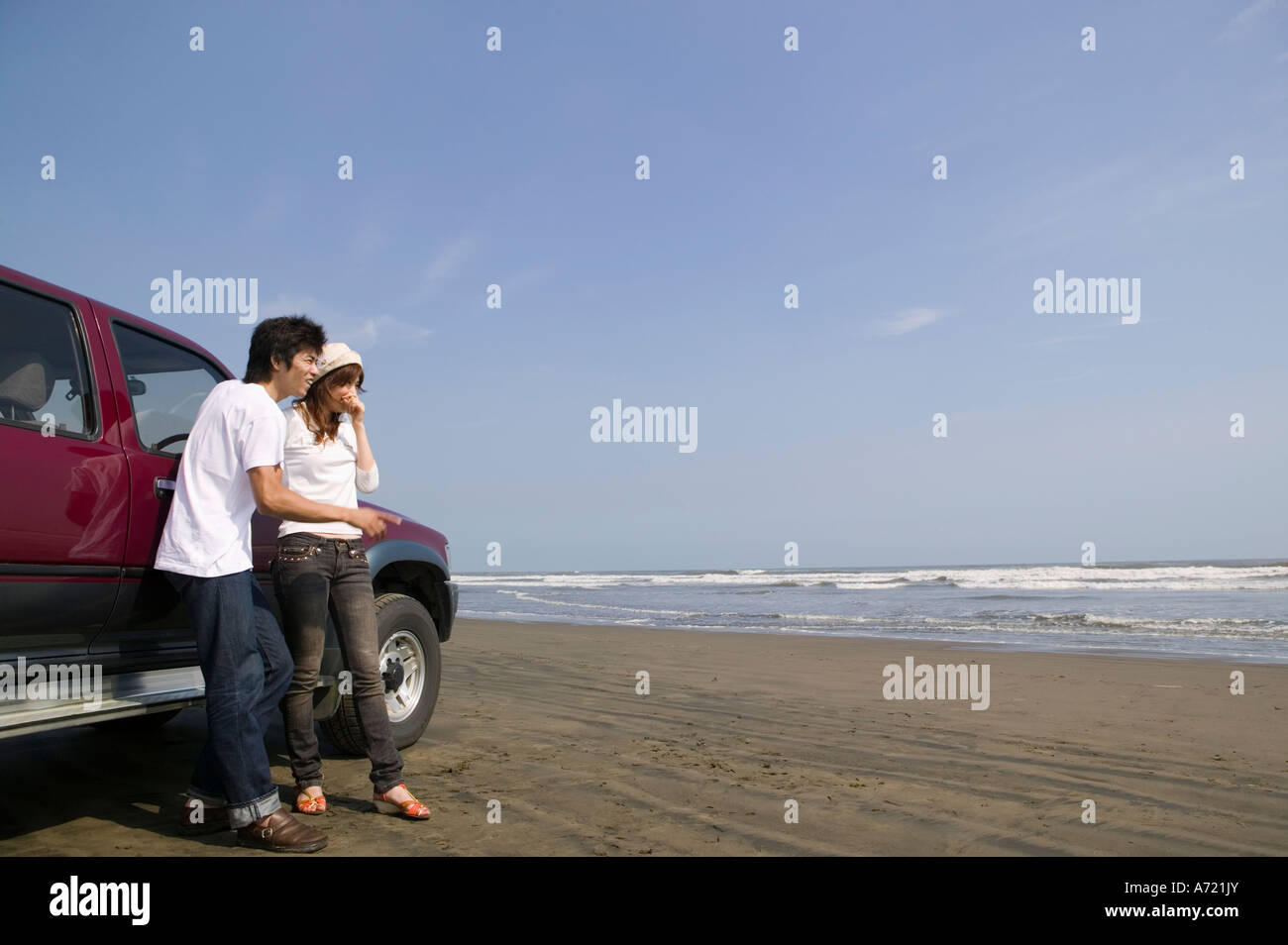 Jeune couple standing on beach Banque D'Images