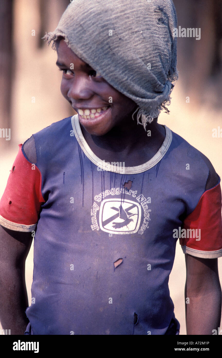 Réfugiés Smiling African boy dans un évangélique bleu T-Shirt faisant le meilleur d'un camp de réfugiés au Zimbabwe Banque D'Images