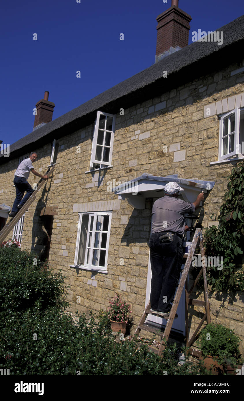 Europe, France, Régions, Abbotsbury. Les hommes travaillant sur old house Banque D'Images