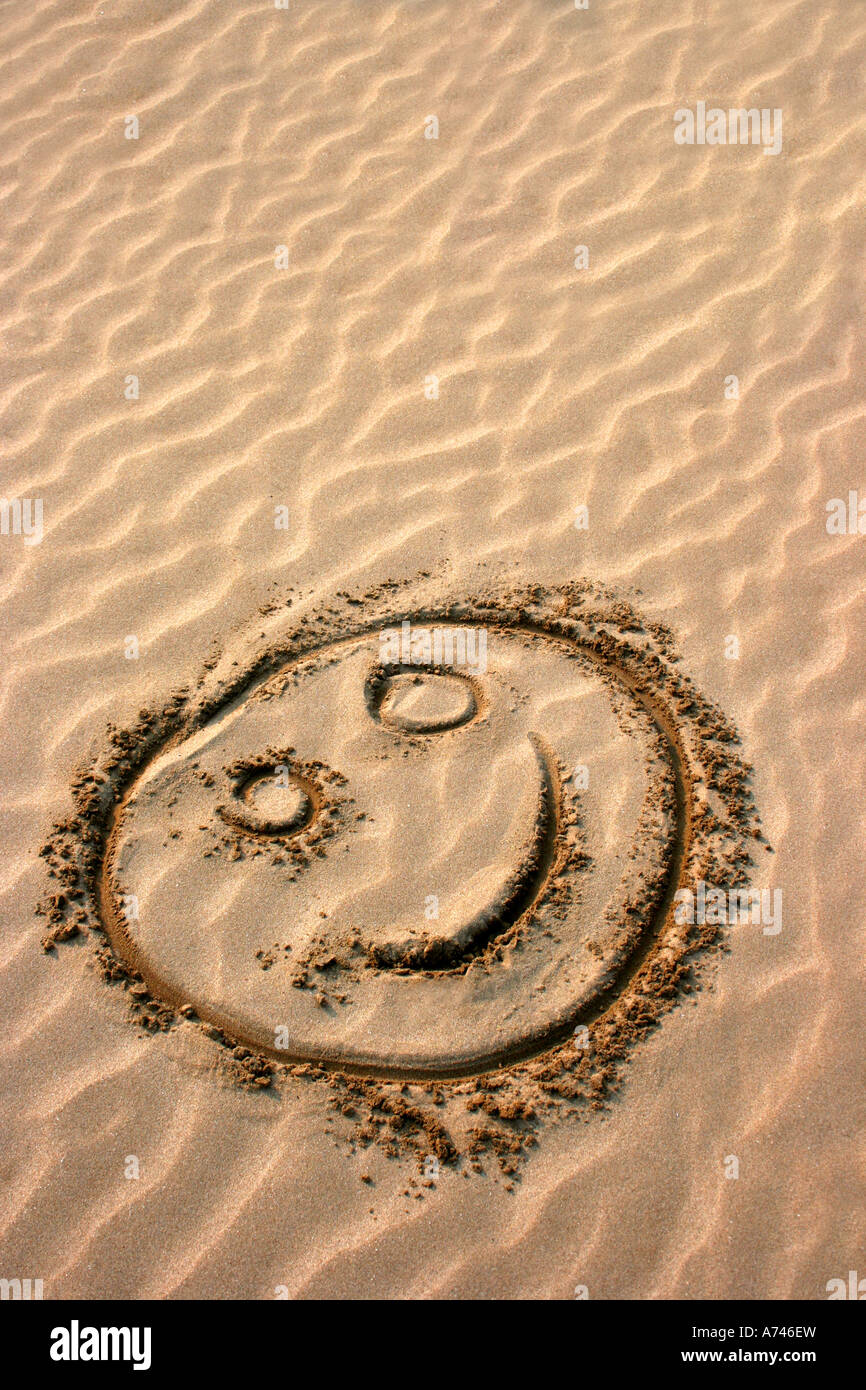Smiley dessiné dans le sable doré, comté de Donegal, en République d'Irlande Banque D'Images