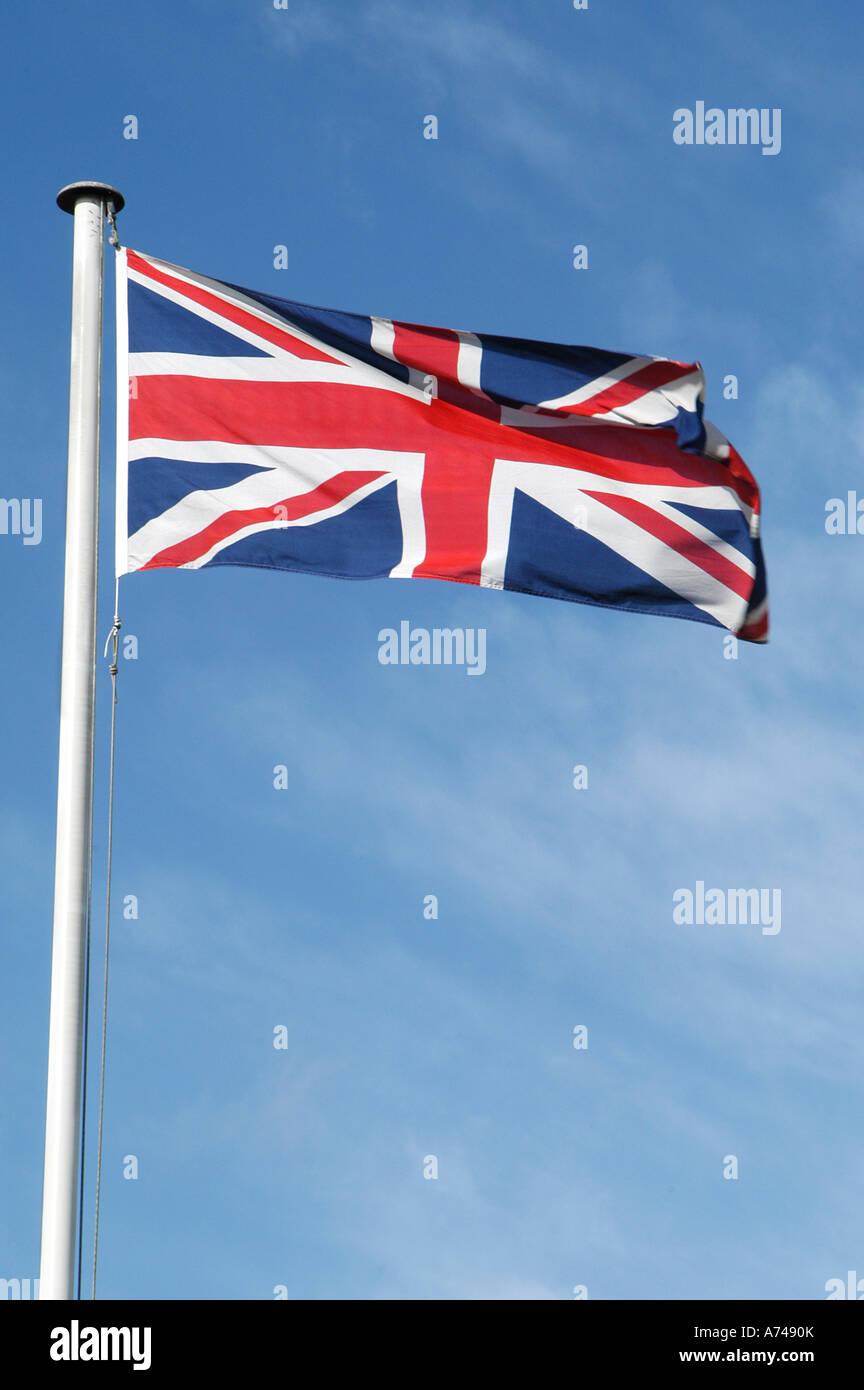 Union jack flag voltigeant dans le vent contre un ciel bleu Banque D'Images