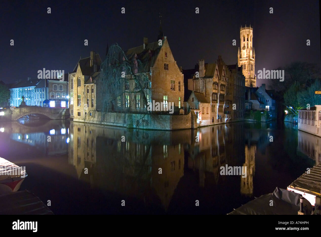 Paysage urbain horizontal la nuit du beffroi de Bruges ou de Belfort van Brugge de l'autre côté du canal à Rozenhoedkaai à Bruges. Banque D'Images