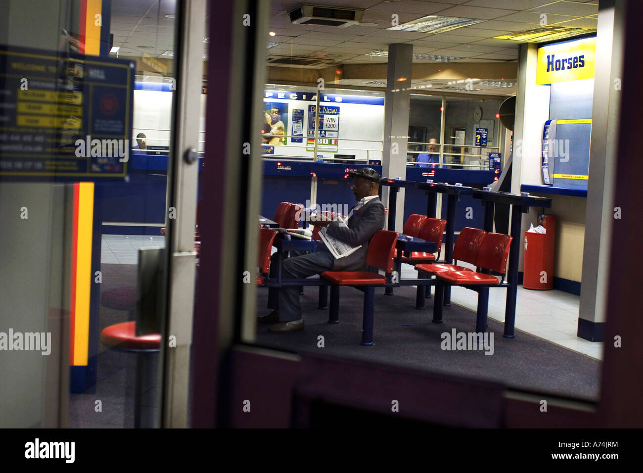 Un homme seul est assis dans le bookmaker William Hill, Dalston London UK Banque D'Images