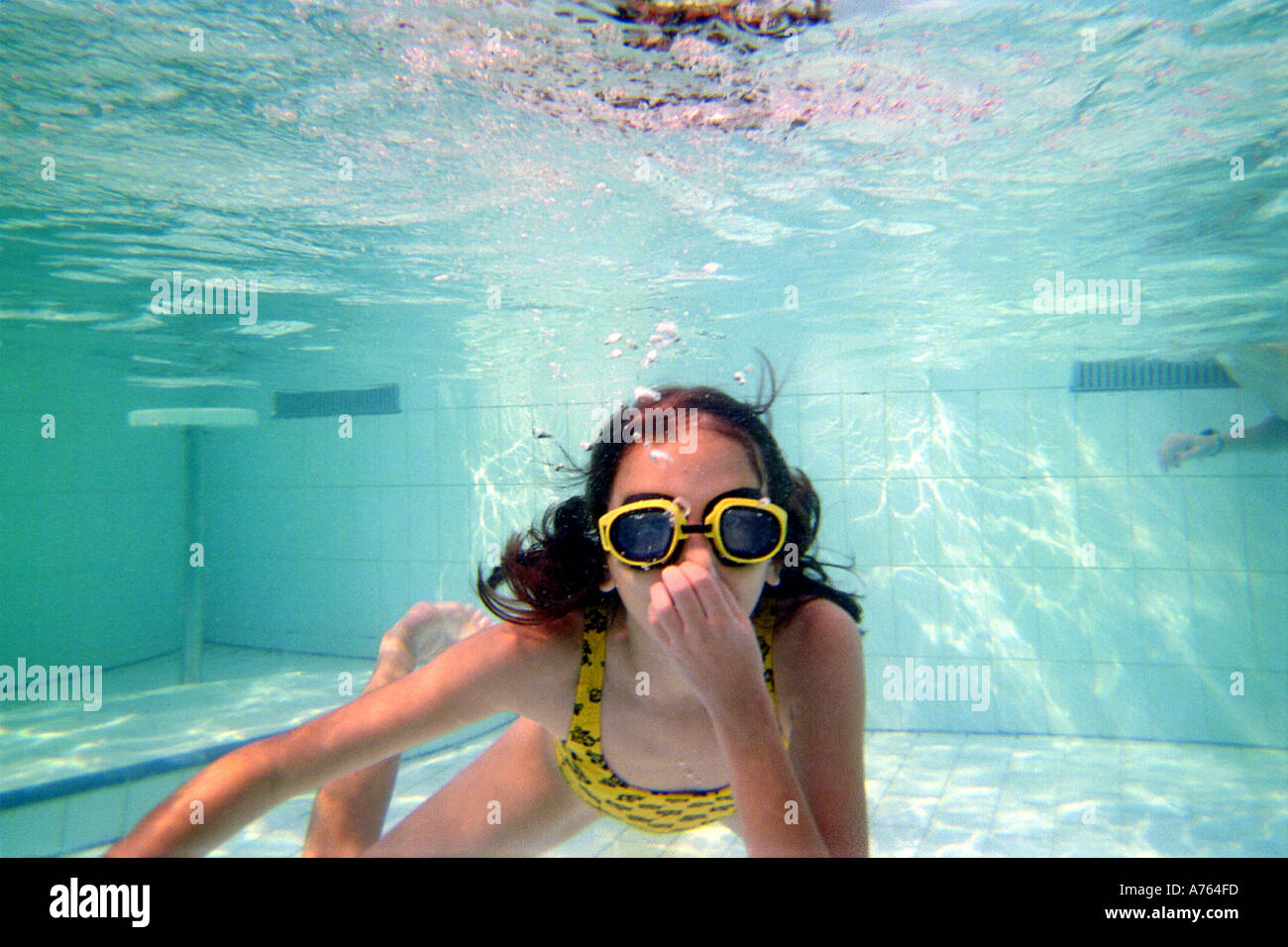 Jeune fille portant ces lunettes et nager sous l'eau Banque D'Images