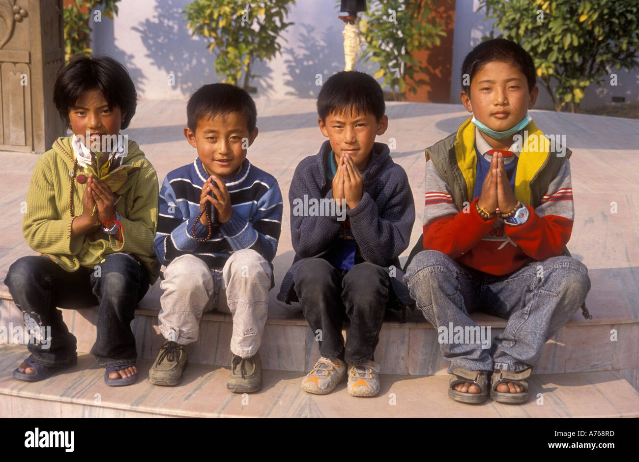 Charmant quatre garçons tibétains posent pour une photo dans le Parc des Cerfs Sarnath Inde Banque D'Images