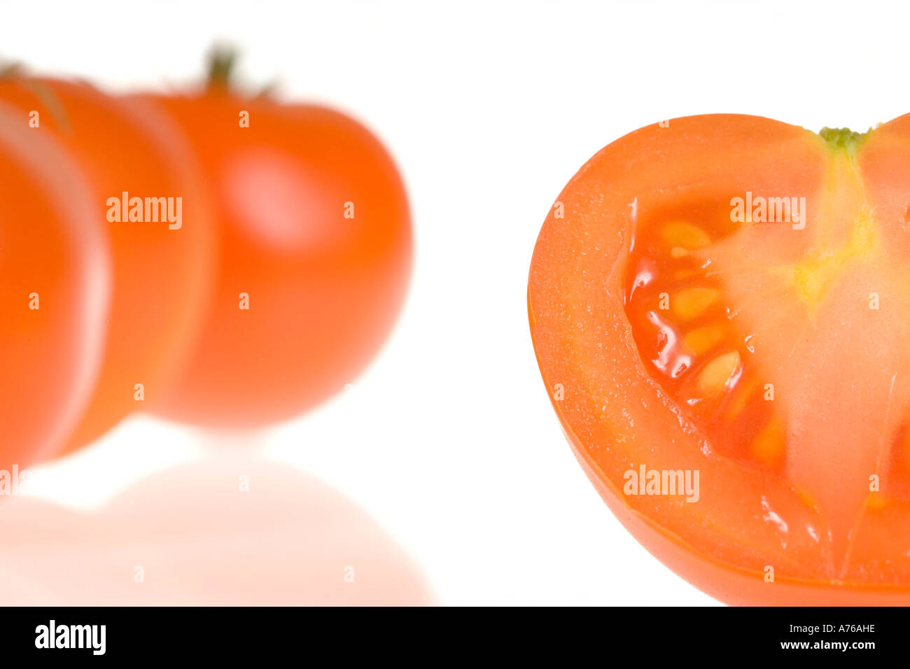 Une partie de trois tomates et une moitié sur un fond blanc, pur. Banque D'Images