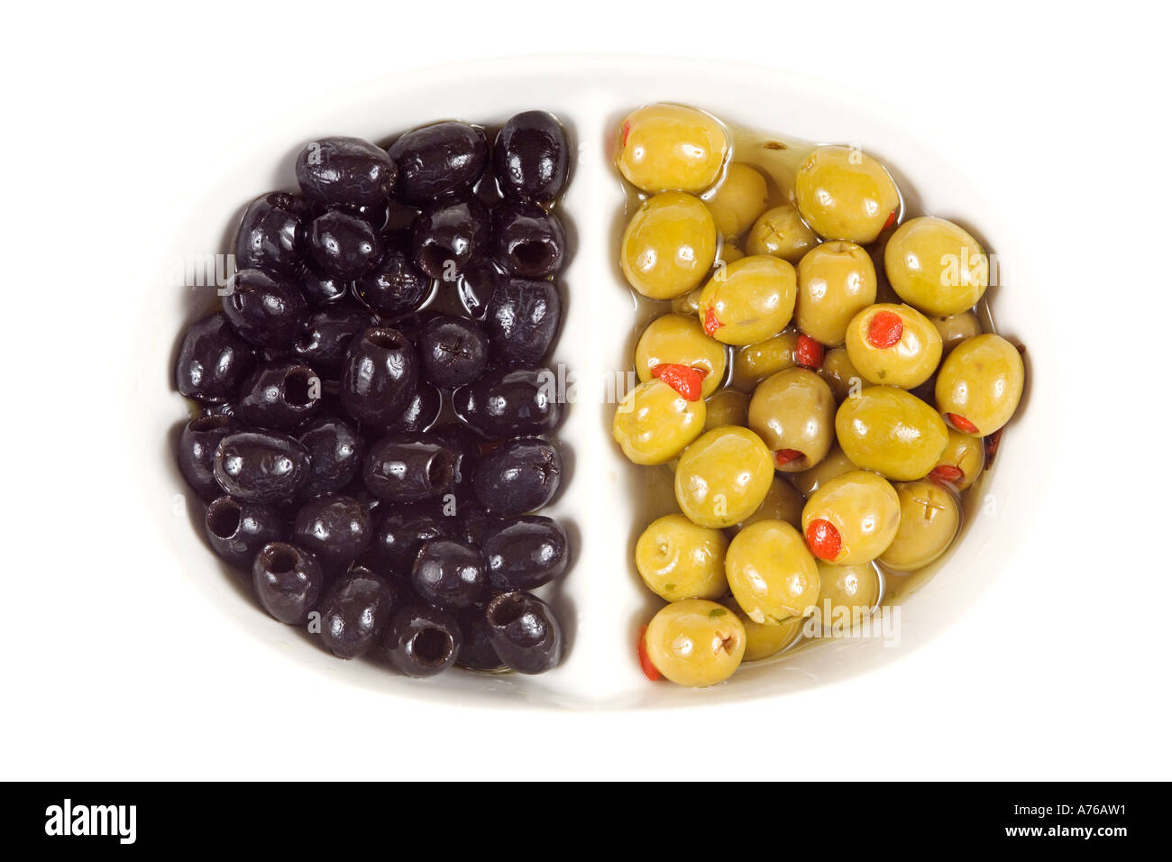 Olives vertes farcies et noir (Olea europaea) sur un fond blanc, pur. Banque D'Images
