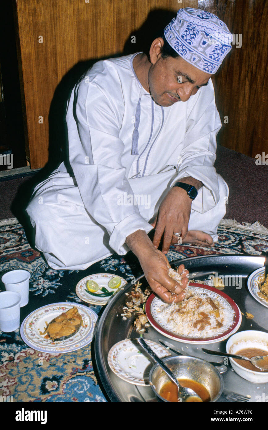 L'homme de manger le déjeuner d'Omanais du riz blanc et la sauce de poisson, Nizwa, Oman Banque D'Images