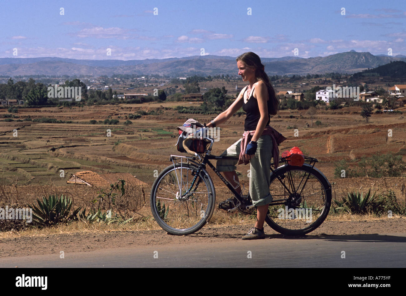 Cycliste européen féminin sur le vélo dans le paysage malgache ouvert Banque D'Images