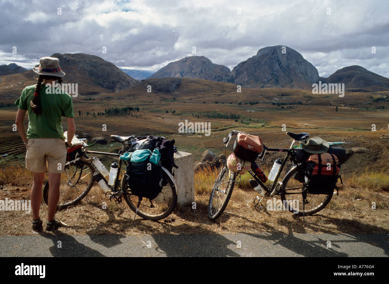 Femme debout à côté de l'expédition de deux bicyclettes au paysage malgache avec montagnes en arrière-plan Banque D'Images