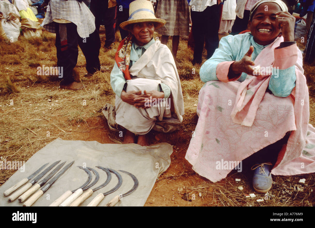 Décrochage du marché dans le centre de village malgache couteaux vente avec deux femmes un sourire et de l'un à la sceptique Banque D'Images