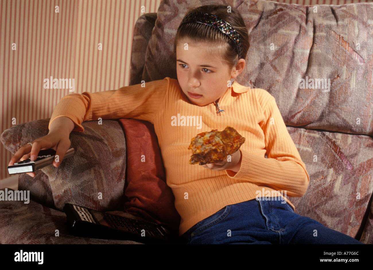 Enfant de manger une pizza en face de T V Banque D'Images