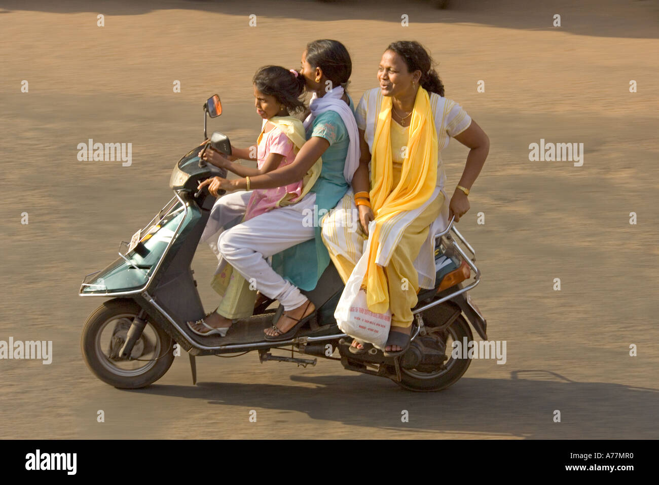 3 femmes (soeurs ?) sur un cyclomoteur ne portaient pas de n'importe quel casque - très commun en Inde ! Banque D'Images