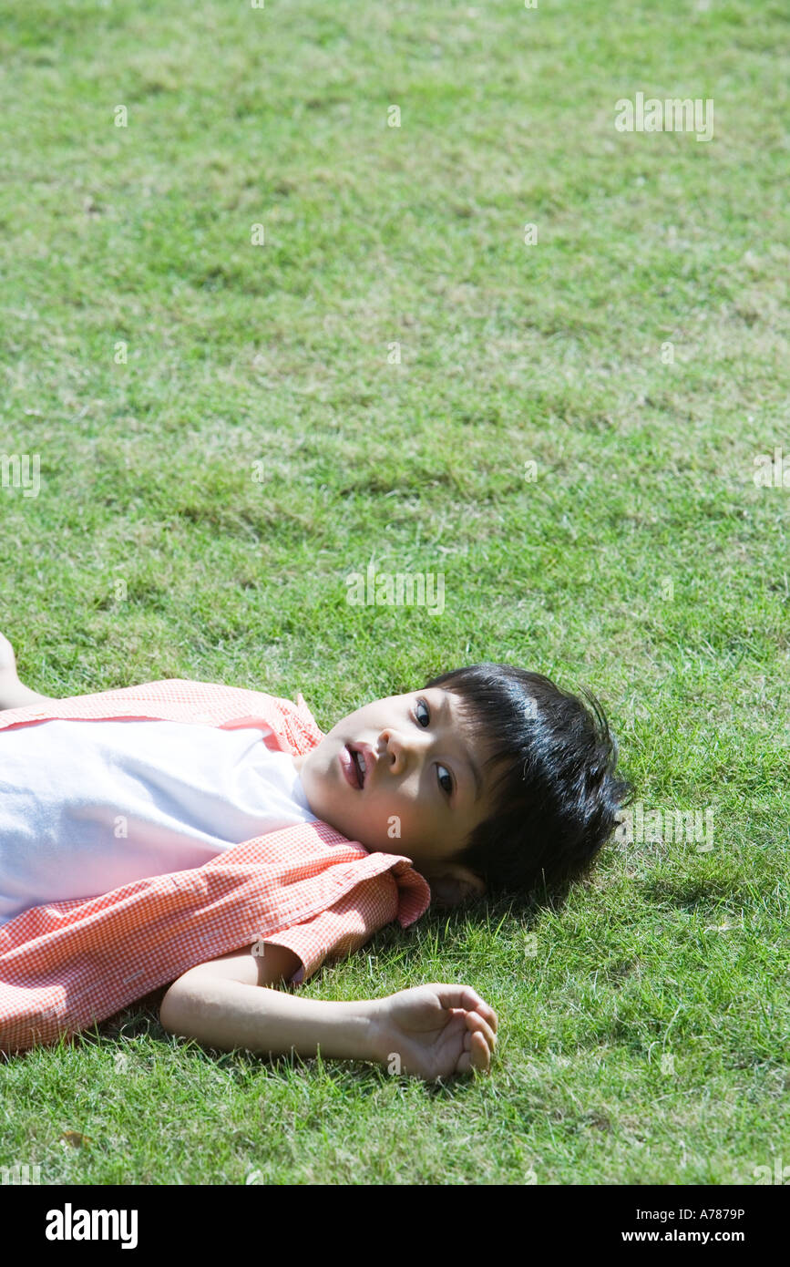 Boy lying on grass Banque D'Images