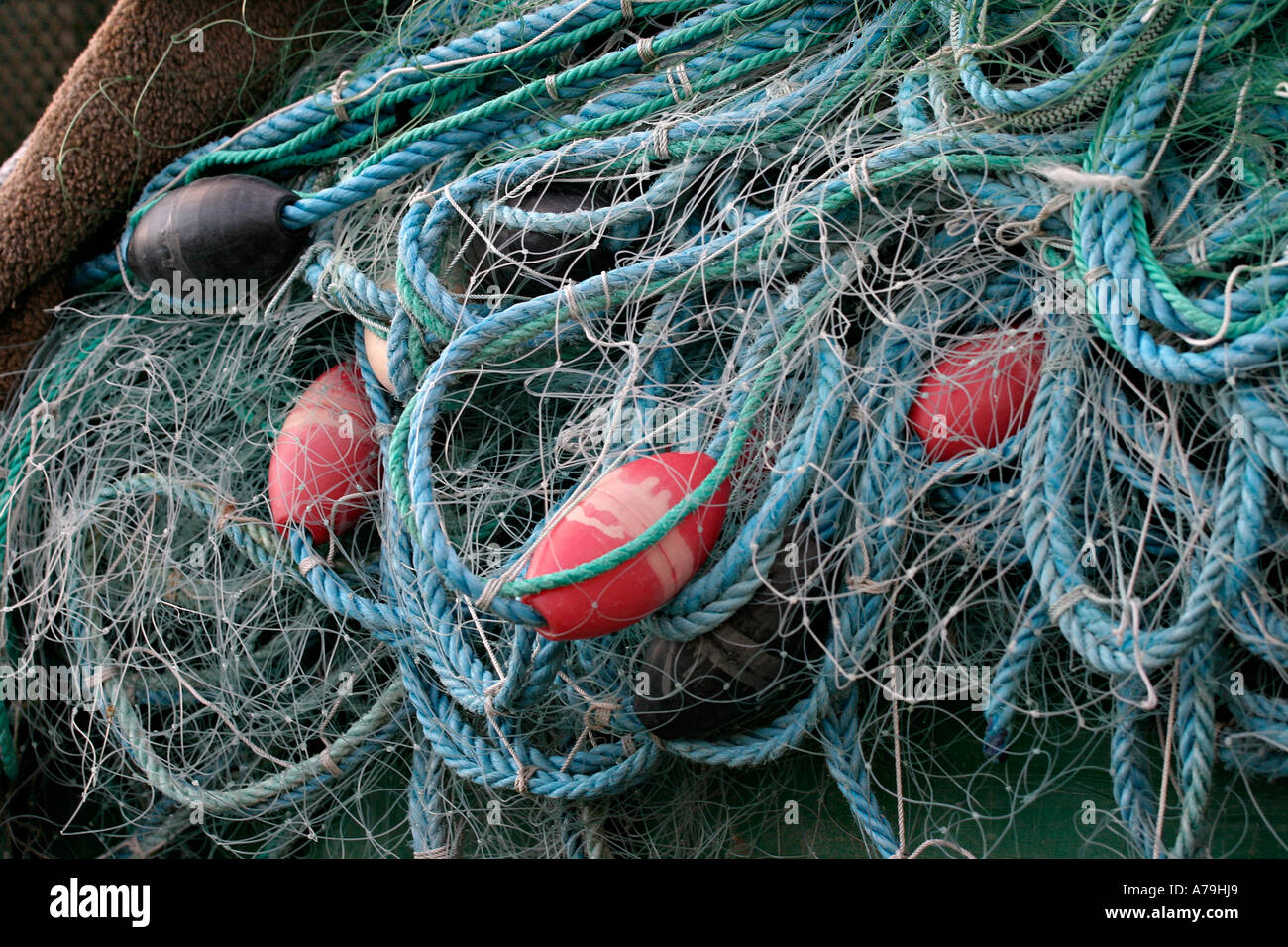 Filets empilés soigneusement pliés : moustiquaires avec corde bleu et orange lignes flotteurs Bunbeg Harbor County Donegal Ireland Banque D'Images