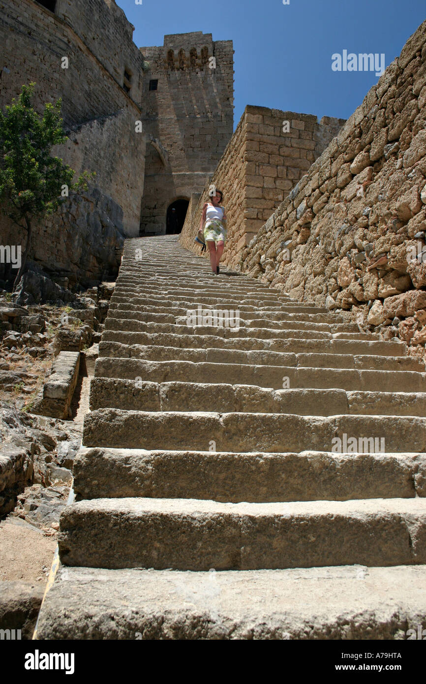 Escalier de l'Acropole de Lindos : Une jeune femme marche dans le long escalier qui mène vers les fortifications entourant le château Banque D'Images