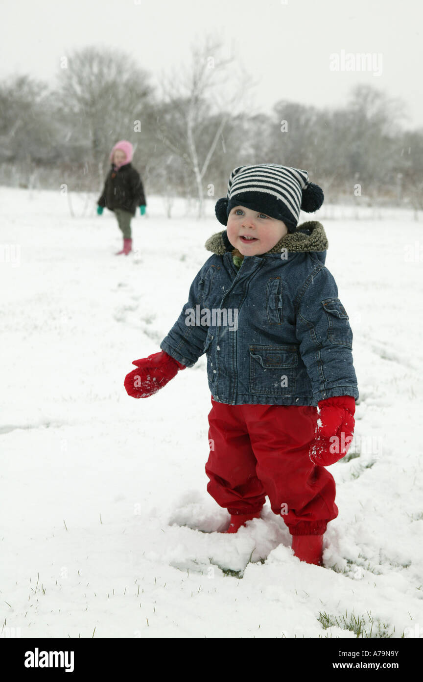 Petit enfant dans un pantalon rouge jouant dans un paysage de neige d'hiver  aussi portant un chapeau à rayures bleu et blanc image innocent doux Photo  Stock - Alamy