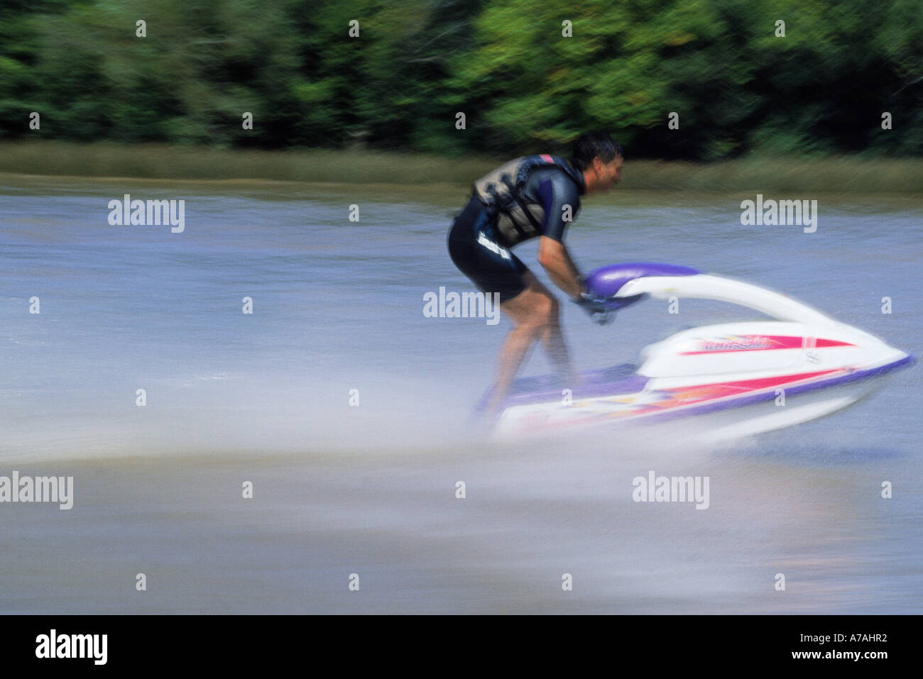 Homme portant un gilet de sauvetage et combinaison de course jet ski sur la rivière Banque D'Images
