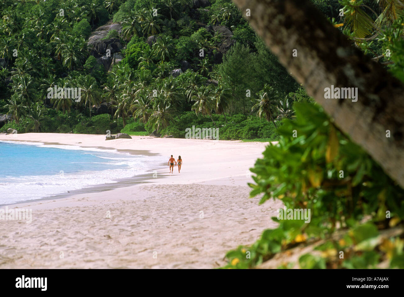Couple en train de marcher le long de Anse Intendance shore sur l'île de Mahé aux Seychelles Banque D'Images