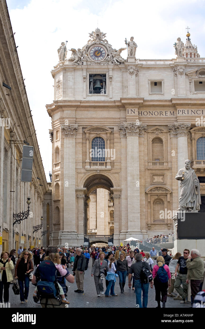 Foule de personnes entrant dans la Basilique Saint Pierre à Rome, en Italie, avec la statue de saint Pierre sur la droite Banque D'Images