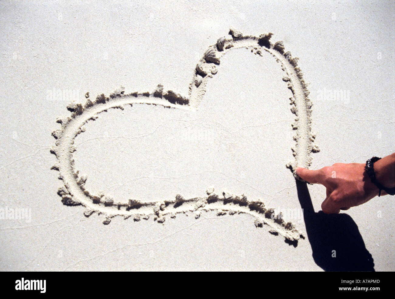 Dessin de la forme d'un coeur dans le sable sur la plage Banque D'Images
