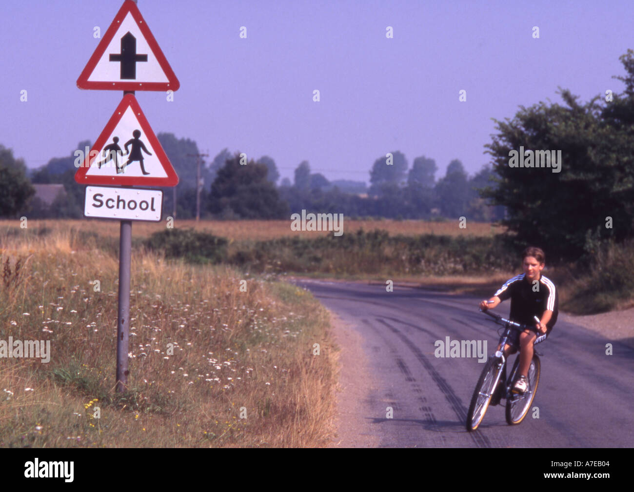 Garçon sur vélo avec signe de l'école Banque D'Images