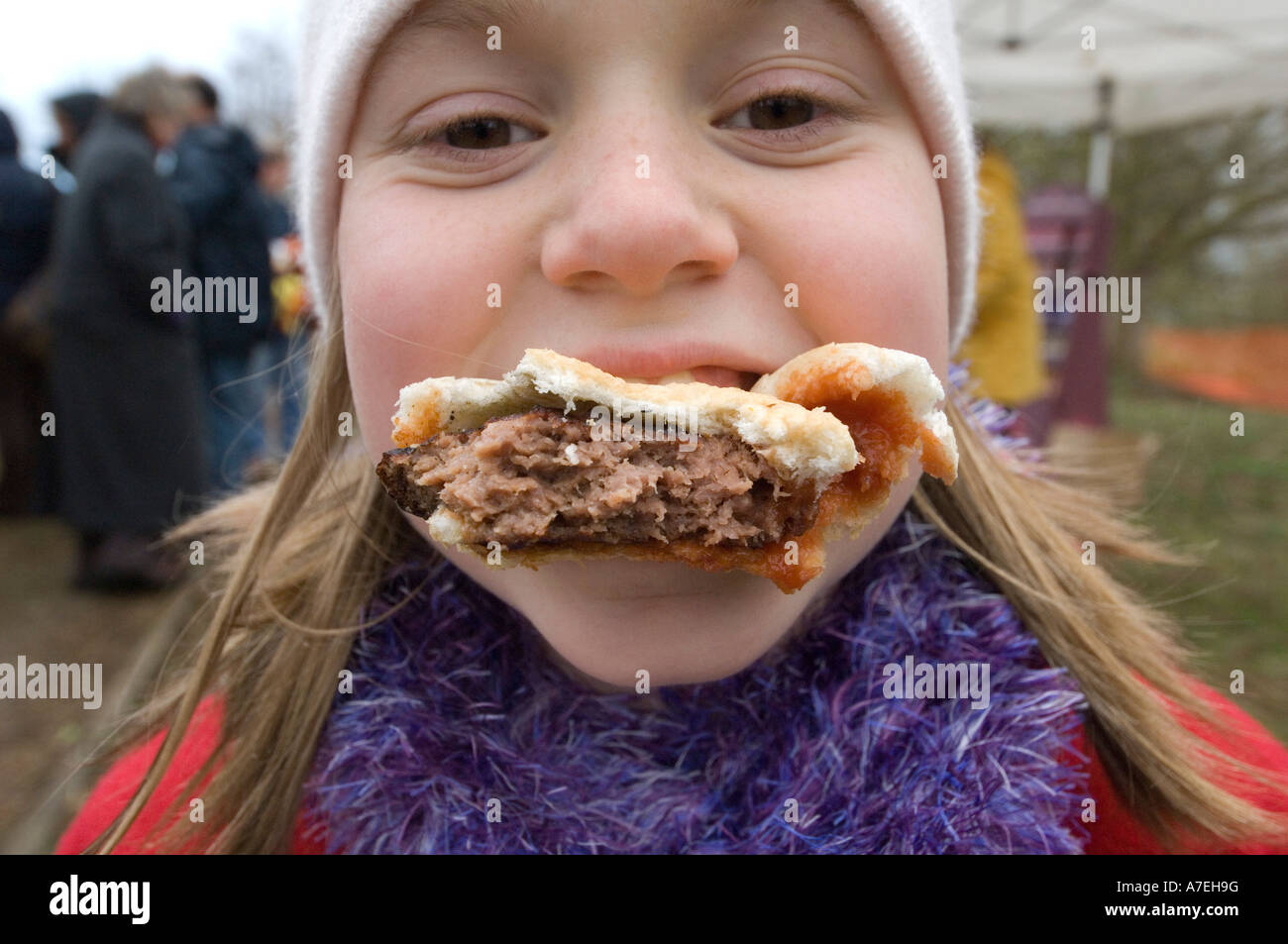 Un enfant mange un hamburger et couverte de sauce tomate ainsi Banque D'Images