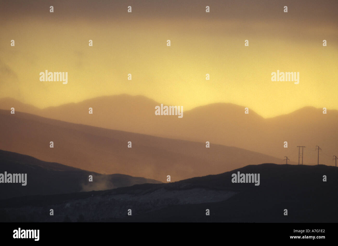 Poteaux télégraphiques sur le sommet d'une colline avec un bean de la lumière au coucher du soleil à travers les montagnes écossais près de Fort William en Écosse Banque D'Images