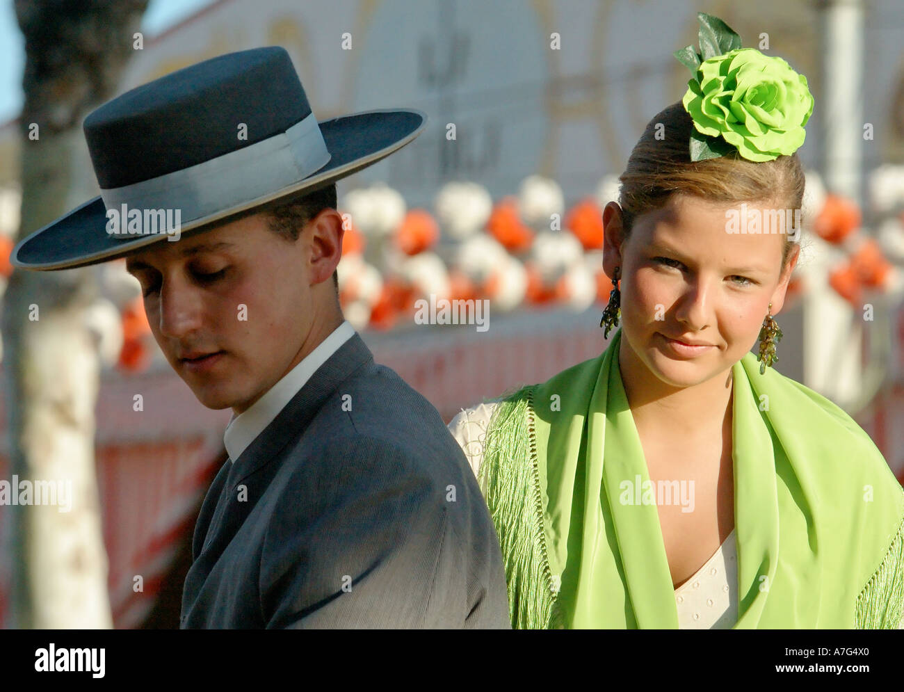 Jeune homme avec une jeune fille en costume traditionnel leurs derrière lui à travers Séville, Foire d'avril - Feria de Abril Banque D'Images