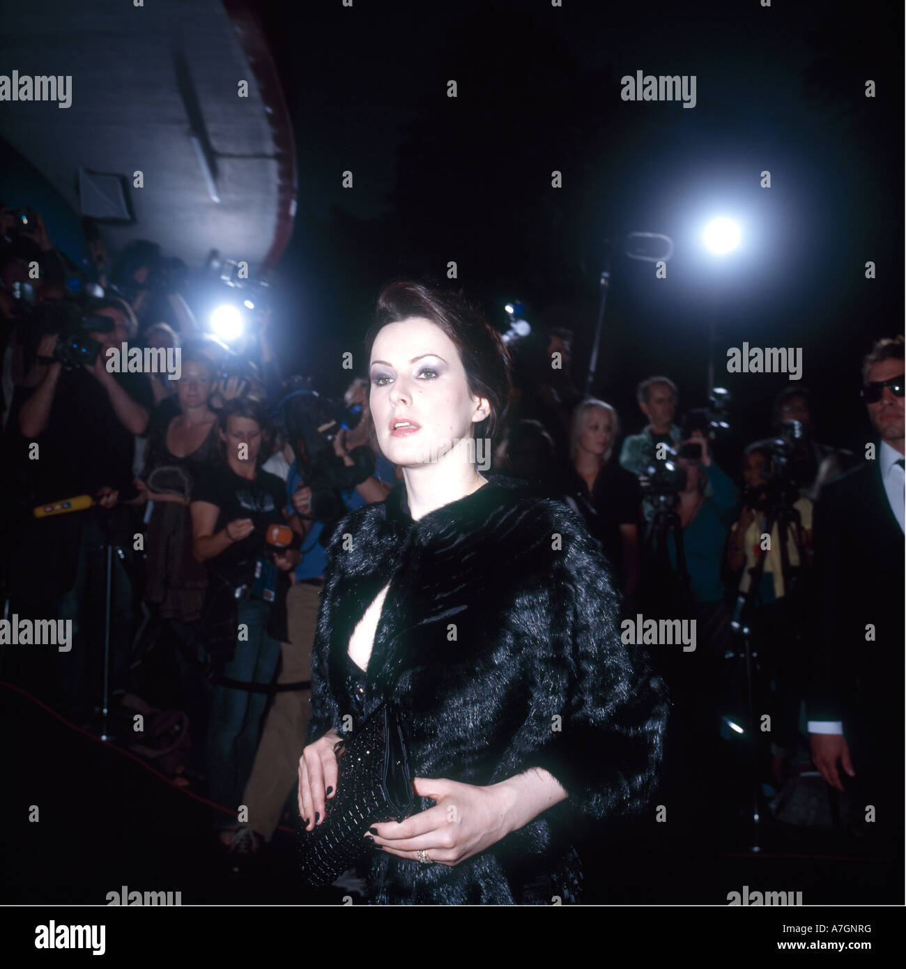 Modèle féminin est choyé avant un tapis rouge soirée dehors. Et joue le rôle d'une star de cinéma célébrité. Banque D'Images
