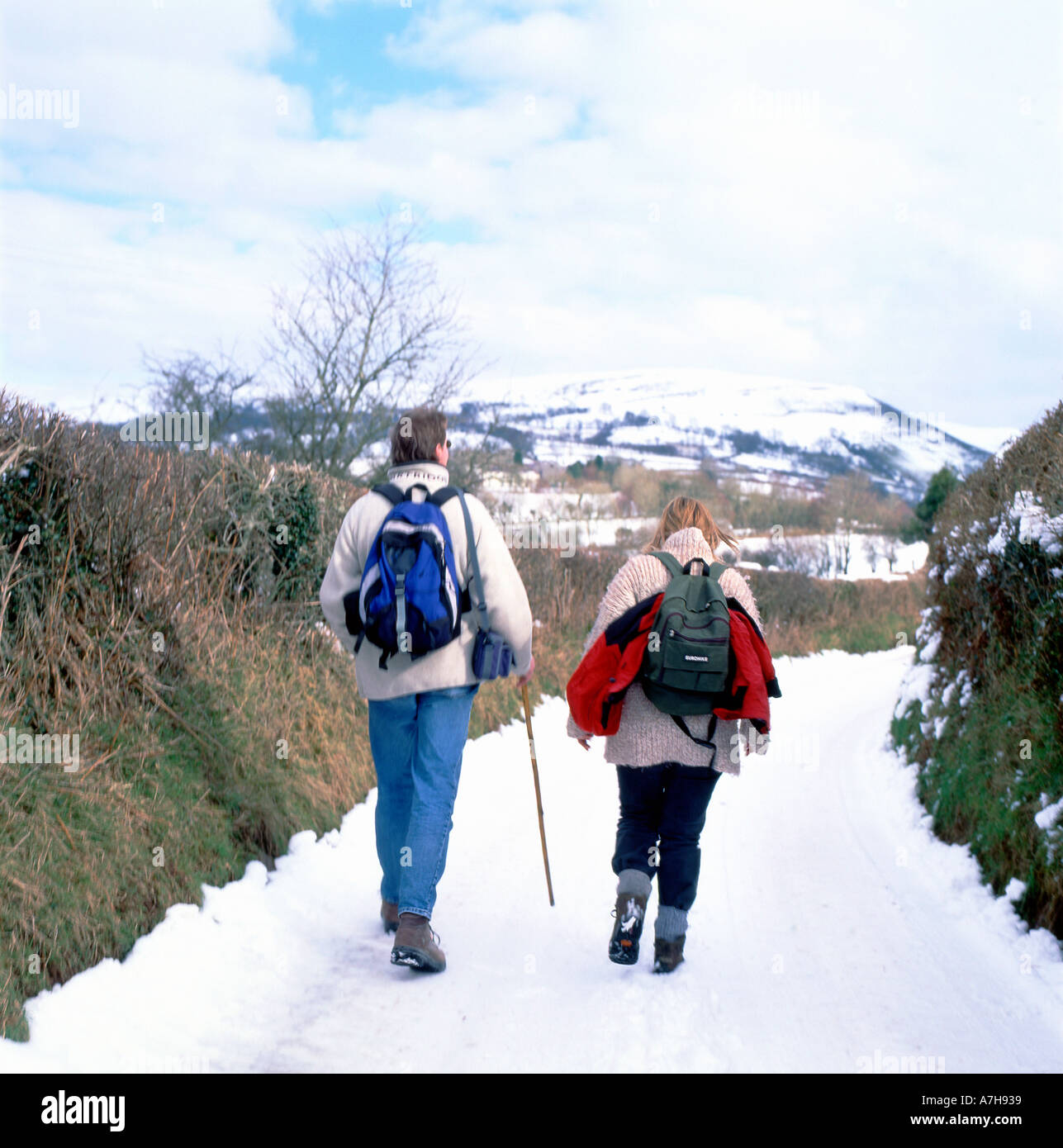 Marcheurs marchant le long d'une route enneigée à Llyn y Fan Dans le parc national de Brecon Beacons, près de Llanddeusant, dans le Carmarthenshire PAYS DE GALLES ROYAUME-UNI KATHY DEWITT Banque D'Images