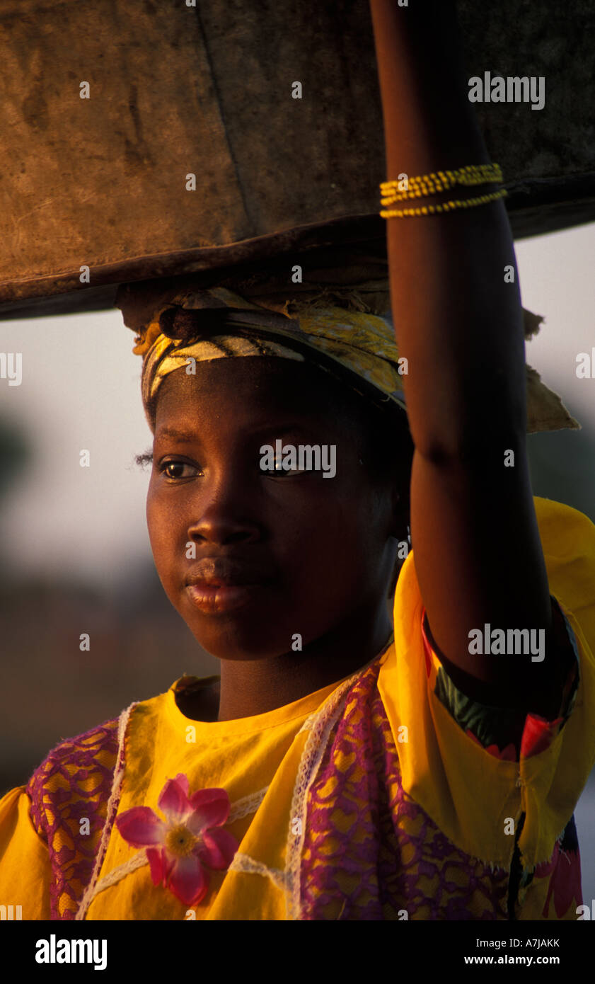 Fille Peul transportant sa vaisselle à laver dans le fleuve, Djenné, Mali Banque D'Images