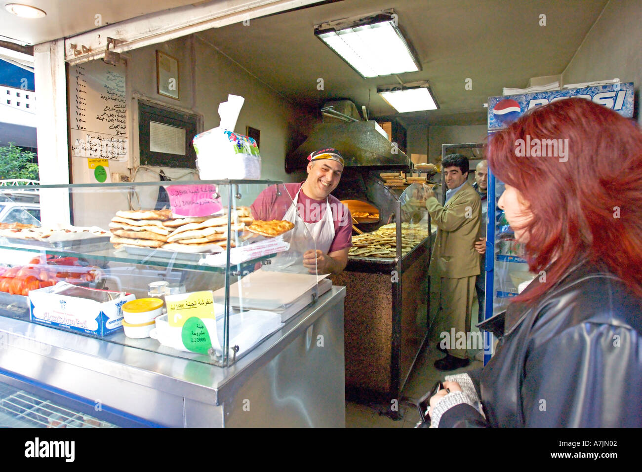 Liban Beyrouth Baker servir les clients un petit-déjeuner typique de zatar libanais une pizza au thym et garnitures d'épices Banque D'Images